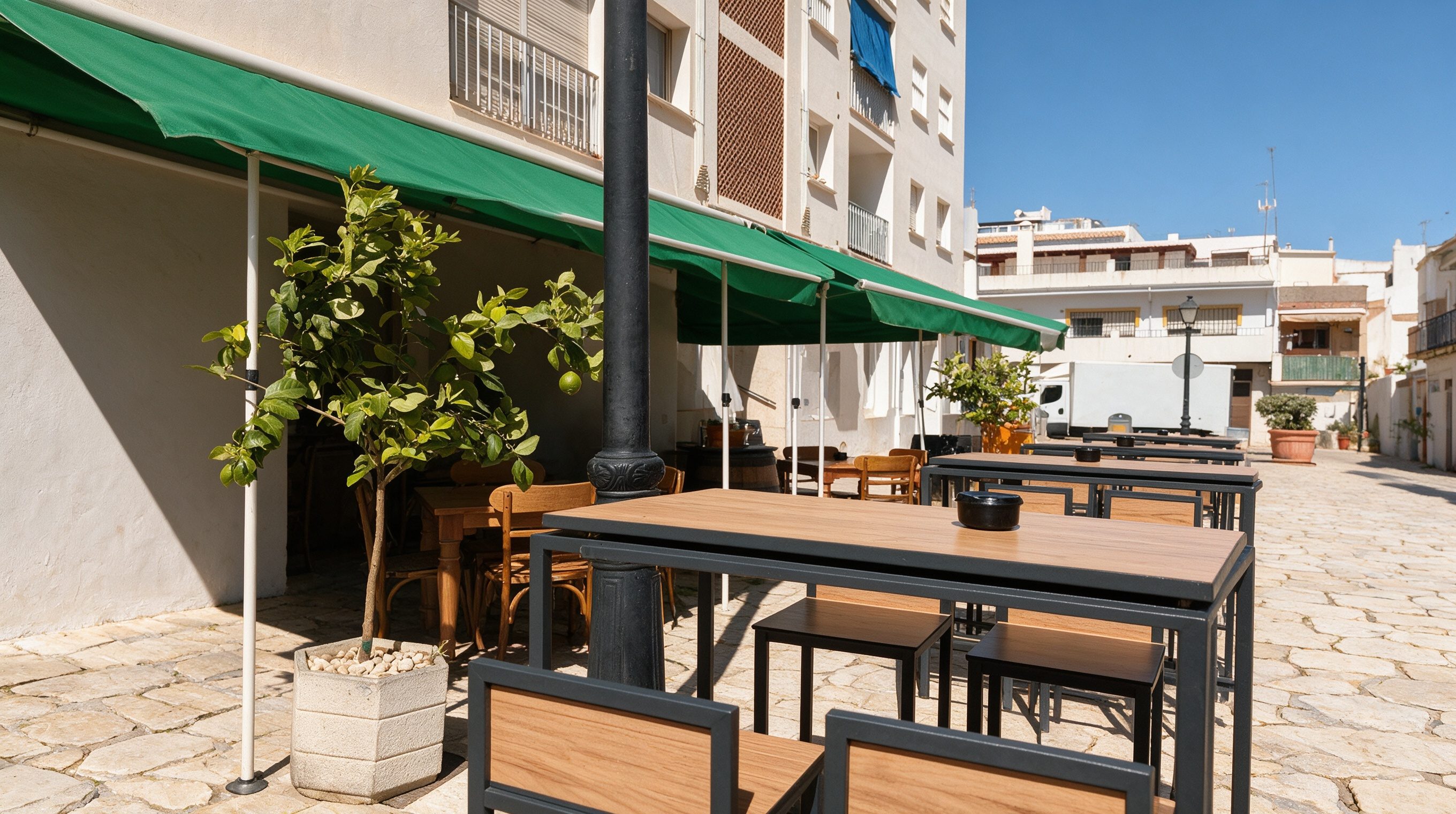 Terraza exterior de La Bodeguita del Paris, toldo verde y calle empedrada
